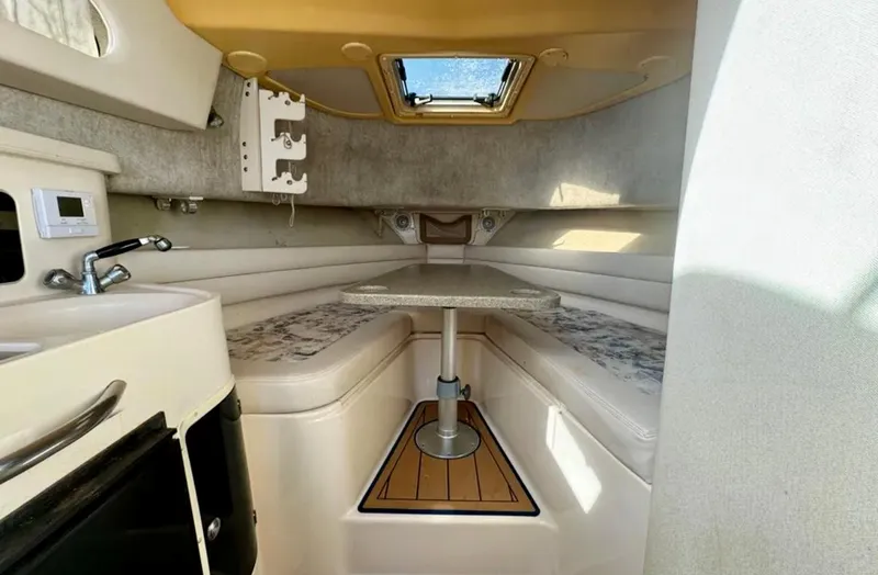 Slide: The Image of 2003 Grady-White Marlin 300 cabin interior with seating, table, and kitchenette. - 33
