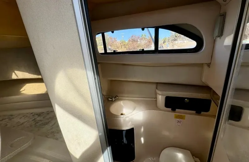 Slide: The Image of 2003 Grady-White Marlin 300 cabin interior with compact bathroom and window view. - 36