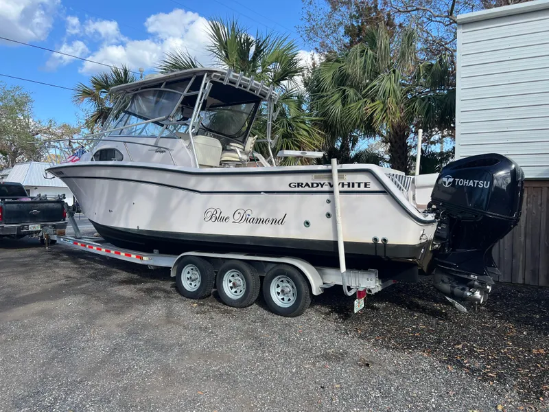 Slide: The Image of 2003 Grady-White Marlin 300 boat on trailer, parked outdoors, with Tohatsu engine. - 41