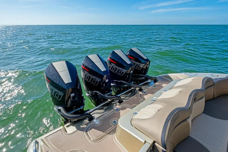 Slide: The Image of Four powerful outboard motors on a 2021 MTI V42 boat, cruising on open water. - 22