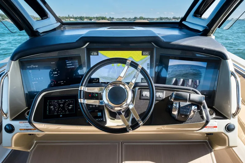Slide: The Image of Cockpit of 2021 MTI V42 boat with advanced navigation screens and steering wheel. - 37