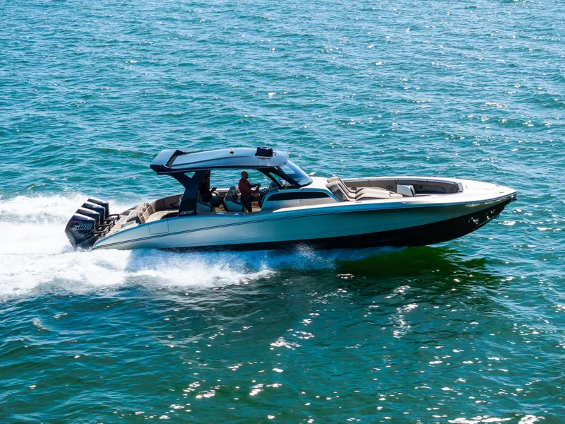 Slide: The Image of 2021 MTI V42 boat cruising on open water, showcasing sleek design and powerful engines. - 8