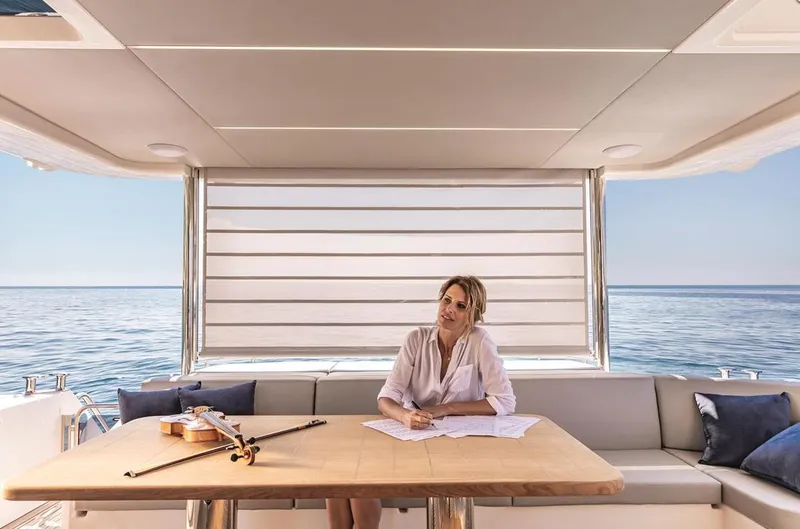 Slide: The Image of Woman relaxing on a luxury yacht, Absolute Fly Co Ownership 2023, with a violin on the table. - 21