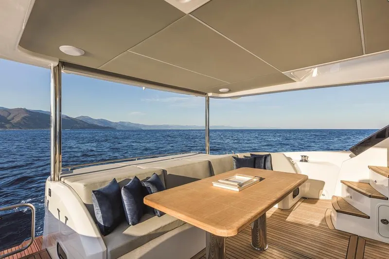 Slide: The Image of Luxurious yacht deck with seating, wooden table, and ocean view, Absolute Fly Co Ownership 2023. - 22
