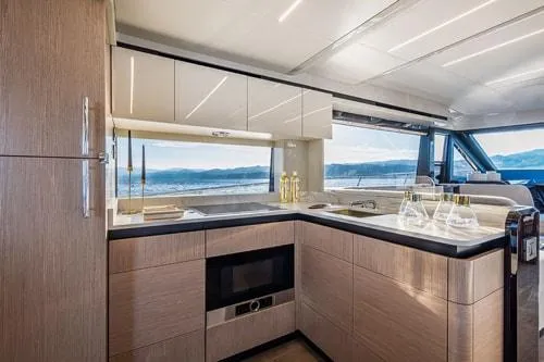 Slide: The Image of Luxurious yacht kitchen interior with modern design, featuring wood cabinetry and scenic ocean view. - 26