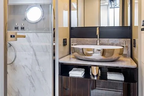 Slide: The Image of Luxurious yacht bathroom with modern sink, marble shower, and porthole window, 2023 Absolute Fly Co Ownership. - 35