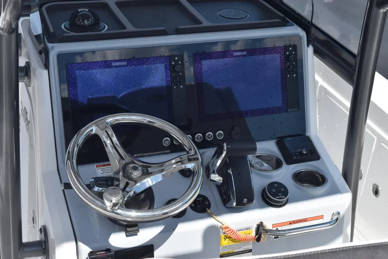Slide: The Image of 2023 Crevalle 26 HCO boat dashboard with dual screens and steering wheel. - 10