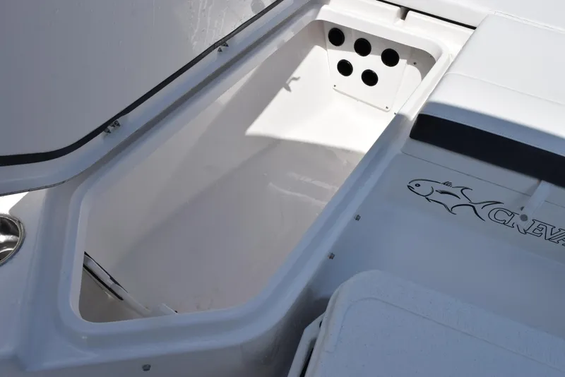 Slide: The Image of Open storage compartment on 2023 Crevalle 26 HCO boat, featuring sleek white interior design. - 19