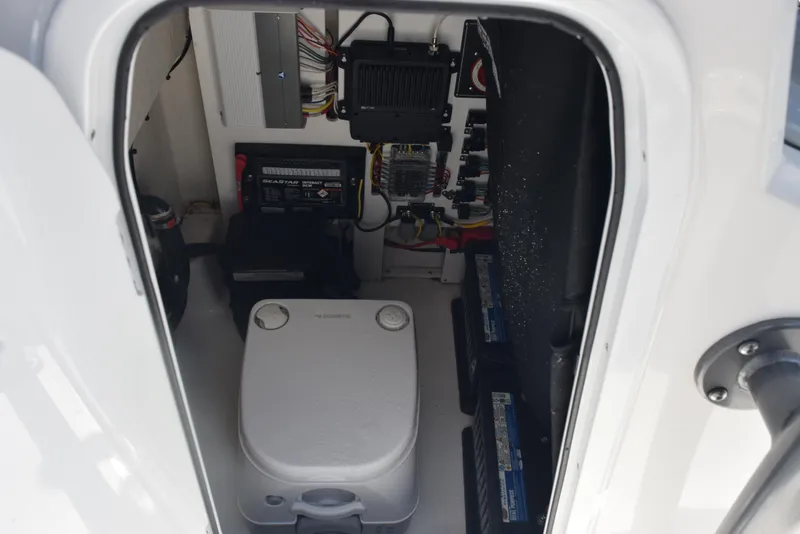 Slide: The Image of 2023 Crevalle 26 HCO boat interior showing electrical components and storage area. - 22