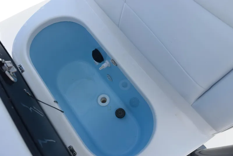 Slide: The Image of Livewell in 2023 Crevalle 26 HCO boat, featuring blue interior and white seating. - 23