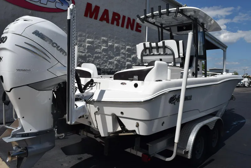 Slide: The Image of 2023 Crevalle 26 HCO boat with Mercury engine on trailer, parked outside marine store. - 4