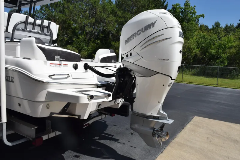 Slide: The Image of 2023 Crevalle 26 HCO boat with Mercury outboard motor, parked outdoors. - 6
