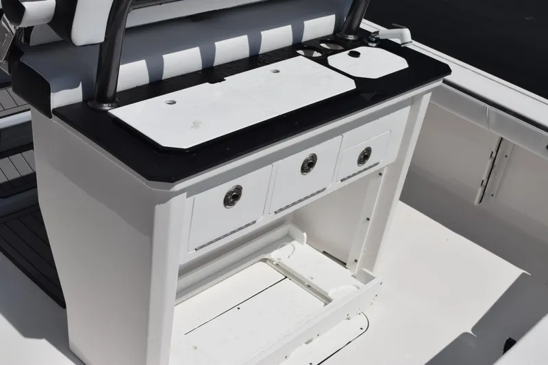 Slide: The Image of 2023 Crevalle 26 HCO boat console with storage drawers and black countertop. - 9