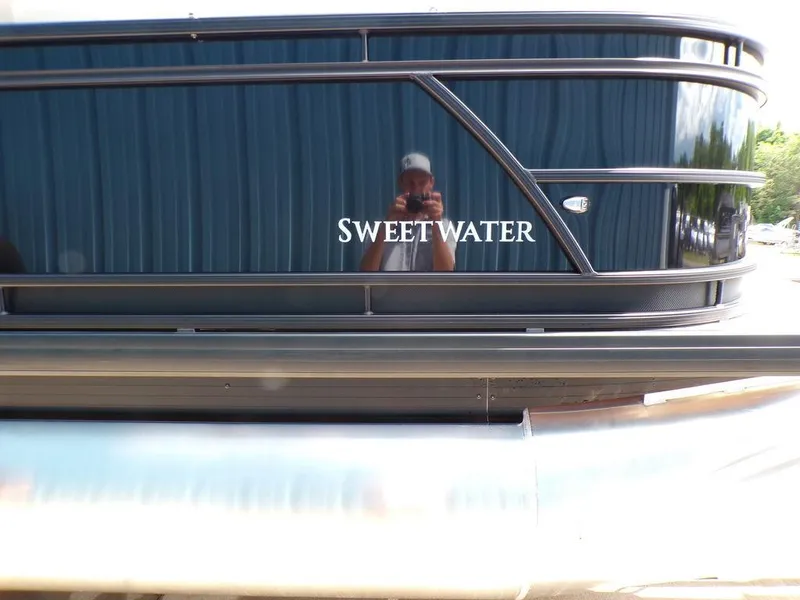 Slide: The Image of 2025 Godfrey Sweetwater 2286 SB pontoon boat with reflective black exterior. - 13