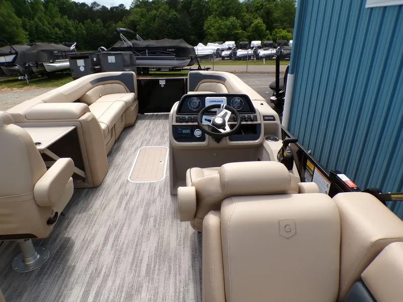 Slide: The Image of 2025 Godfrey Sweetwater 2286 SB pontoon boat interior with beige seating and modern dashboard. - 2