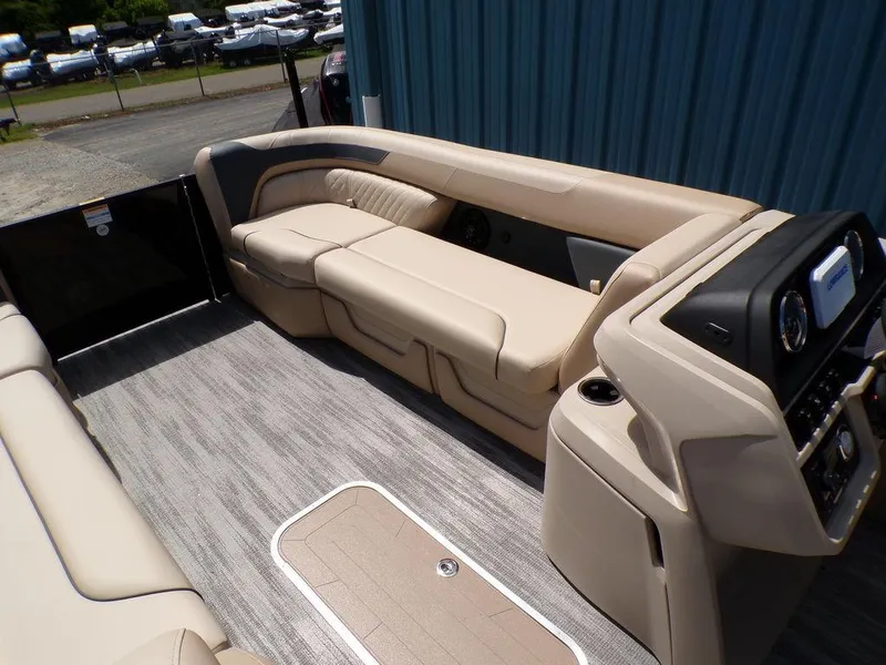 Slide: The Image of 2025 Godfrey Sweetwater 2286 SB boat interior with beige seating and modern console. - 7