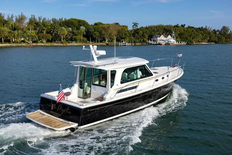 Slide: The Image of 2026 Back Cove 372 cruising on a scenic waterway with lush greenery in the background. - 1