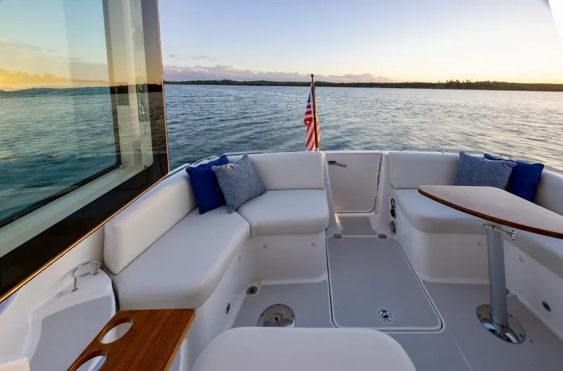 Slide: The Image of Luxurious 2026 Back Cove 372 yacht deck with seating, table, and ocean view. - 3