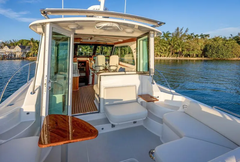 Slide: The Image of 2026 Back Cove 372 yacht with open deck, luxurious seating, and scenic water view. - 4