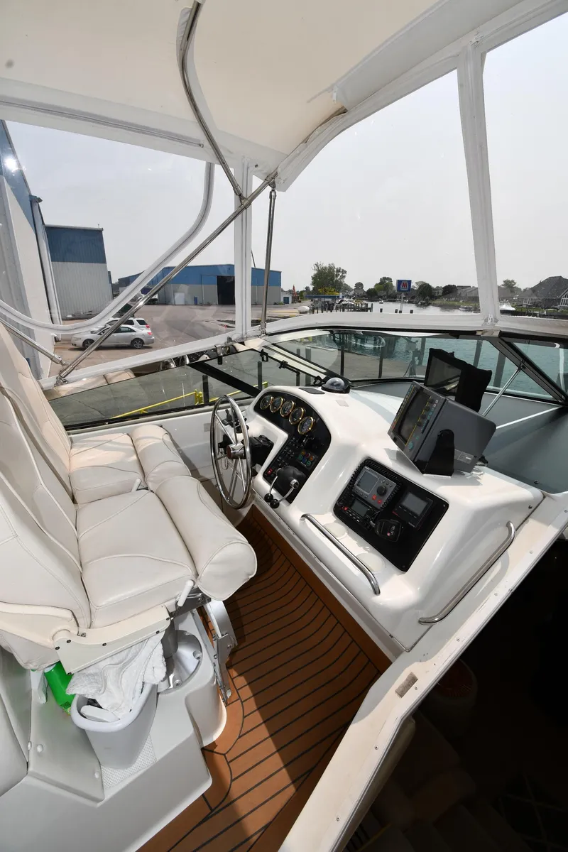 Slide: The Image of 1998 Carver 530 Voyager Pilothouse helm with white seating and modern navigation equipment. - 20