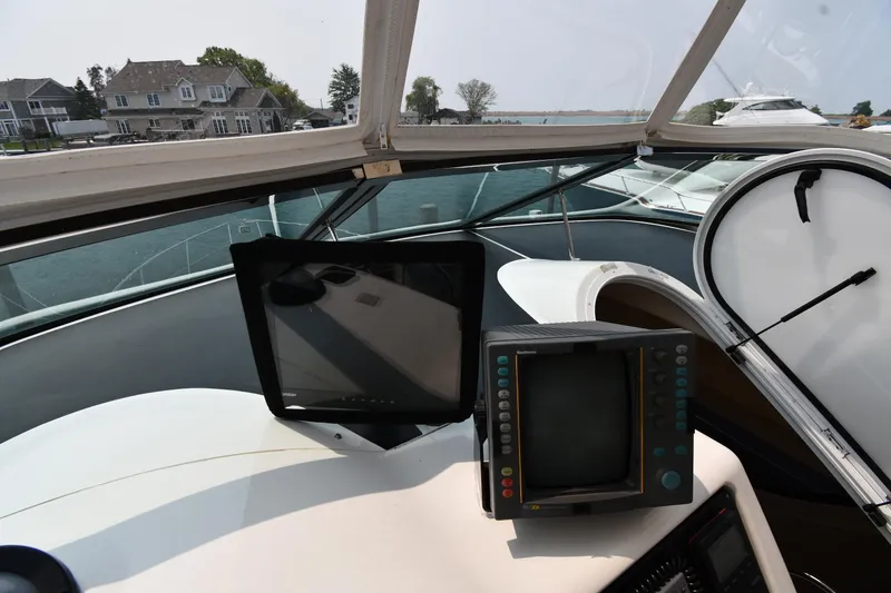Slide: The Image of 1998 Carver 530 Voyager Pilothouse helm with navigation screens and waterfront view. - 21