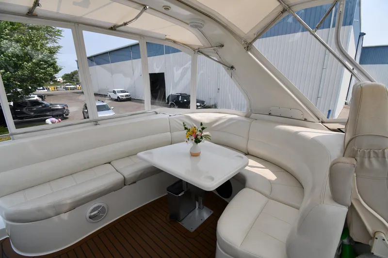 Slide: The Image of 1998 Carver 530 Voyager Pilothouse interior with white seating and table, featuring a floral centerpiece. - 30