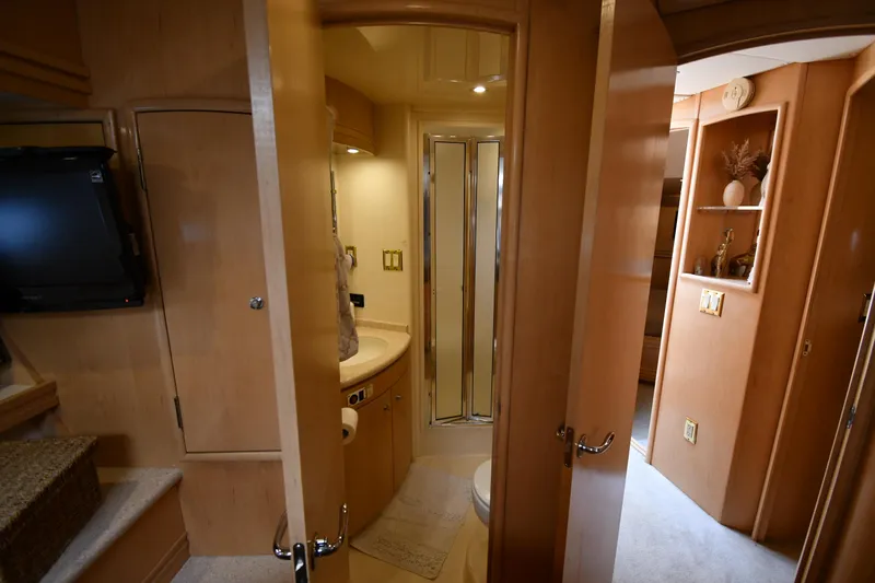 Slide: The Image of Interior of 1998 Carver 530 Voyager Pilothouse, featuring a compact bathroom with wooden cabinetry. - 45