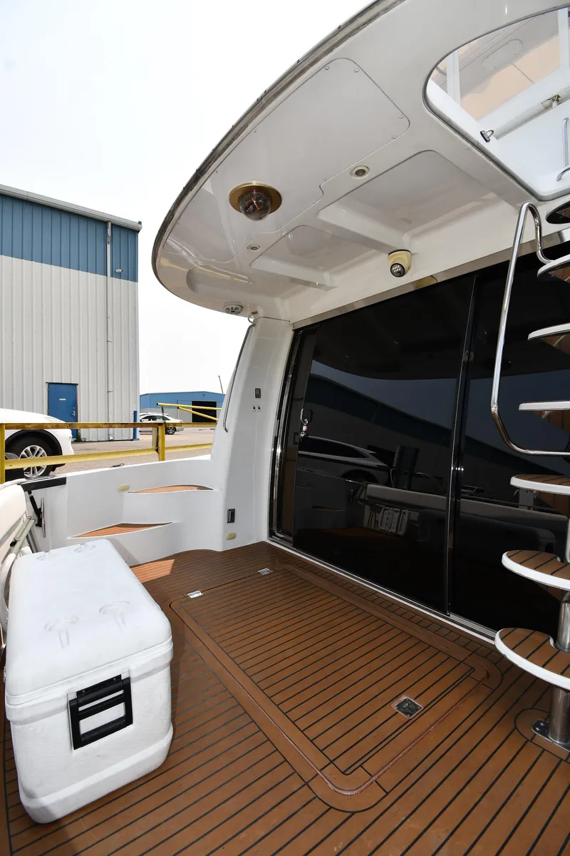 Slide: The Image of 1998 Carver 530 Voyager Pilothouse yacht deck with wooden flooring and spiral staircase. - 12