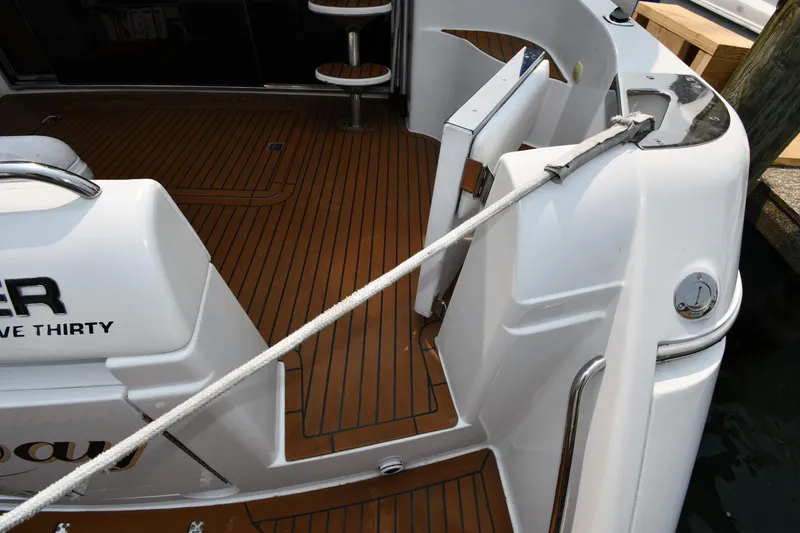 Slide: The Image of 1998 Carver 530 Voyager Pilothouse boat deck with wood finish and mooring line. - 14