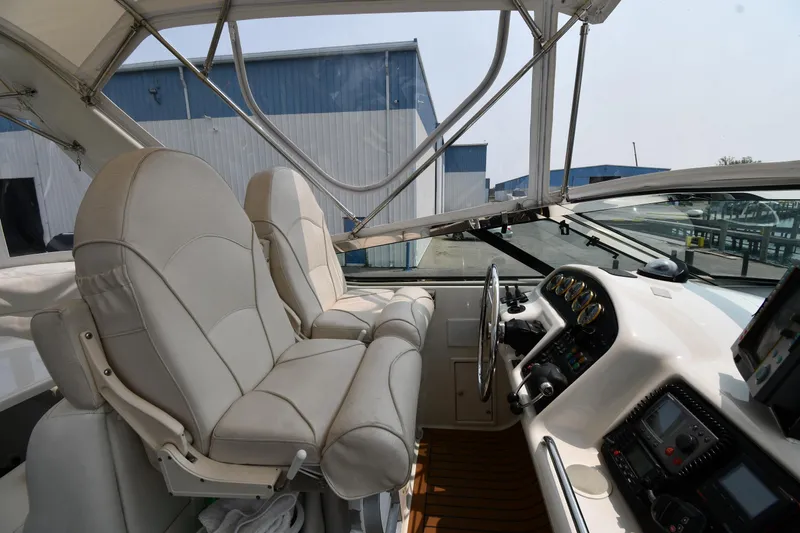 Slide: The Image of 1998 Carver 530 Voyager Pilothouse interior with helm, leather seats, and navigation equipment. - 24