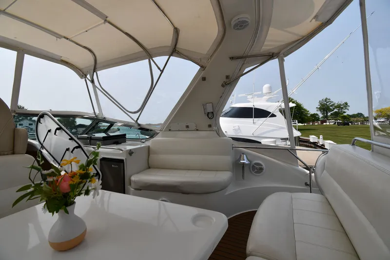 Slide: The Image of 1998 Carver 530 Voyager Pilothouse interior with white seating and floral centerpiece. - 26