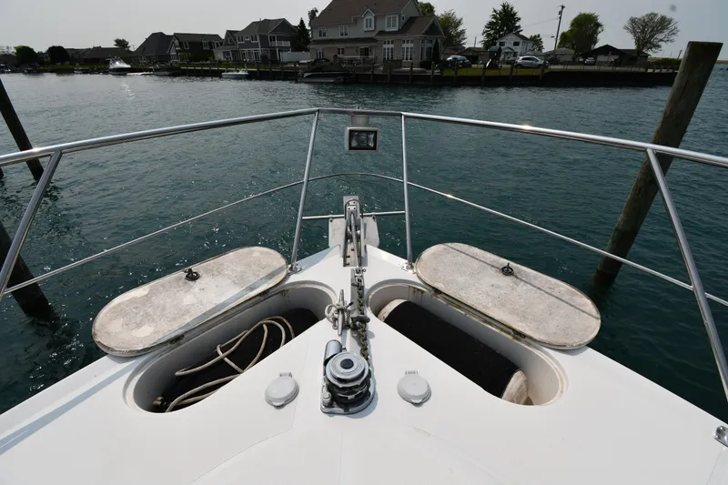Slide: The Image of Bow view of 1998 Carver 530 Voyager Pilothouse, docked near waterfront homes. - 4