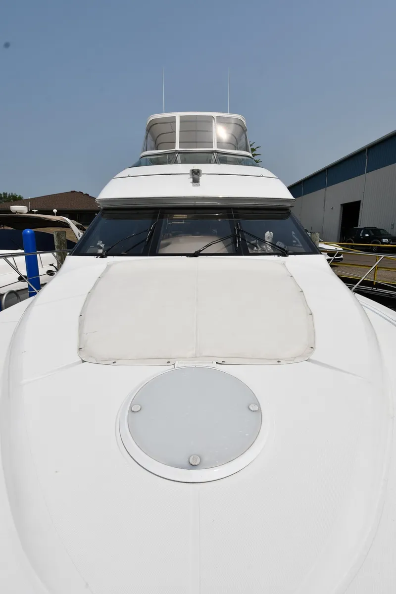 Slide: The Image of 1998 Carver 530 Voyager Pilothouse yacht docked, showcasing sleek design and spacious deck. - 6