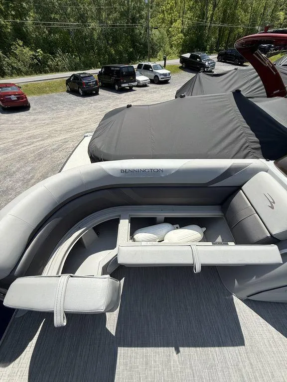 Slide: The Image of 2023 Bennington 22 SXSB pontoon boat with luxurious seating and storage, parked outdoors. - 10