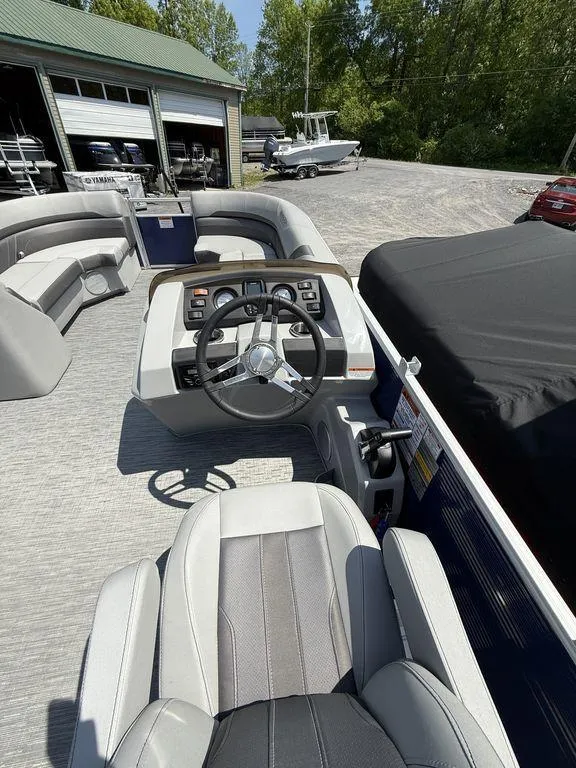 Slide: The Image of 2023 Bennington 22 SXSB pontoon boat interior with steering wheel and seating. - 16