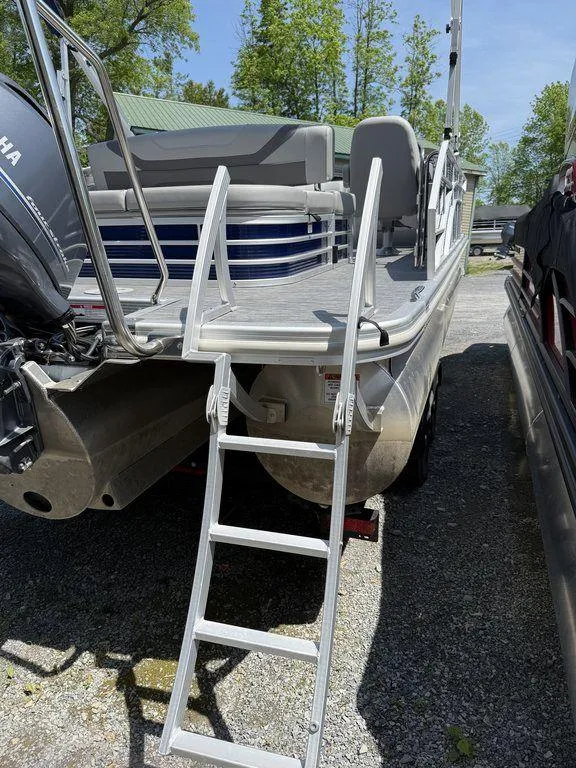 Slide: The Image of 2023 Bennington 22 SXSB pontoon boat with ladder, parked outdoors. - 27
