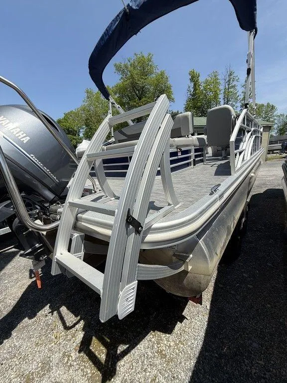 Slide: The Image of 2023 Bennington 22 SXSB pontoon boat with ladder and Yamaha engine, docked outdoors. - 28