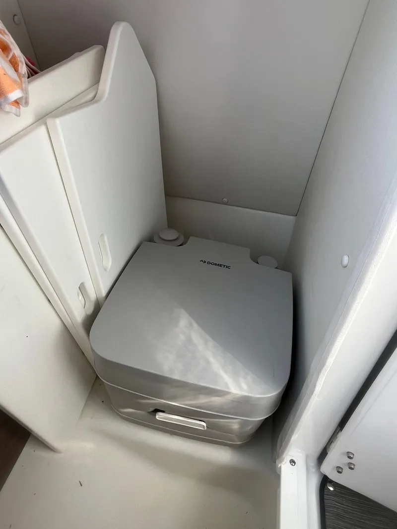 Slide: The Image of Compact portable toilet in a 2021 Scarab 255 ID boat bathroom. - 7