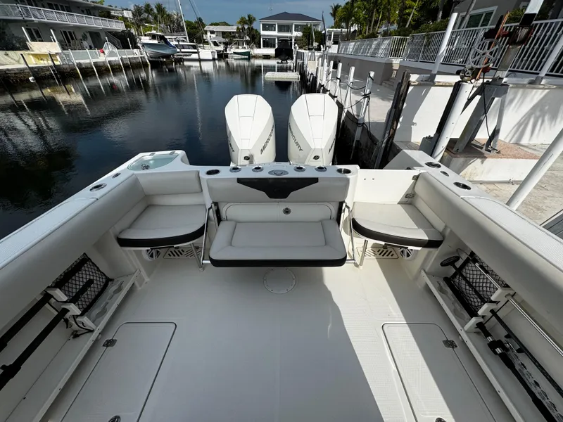 Slide: The Image of 2022 Sailfish 290 CC boat interior with dual engines docked at marina. - 11