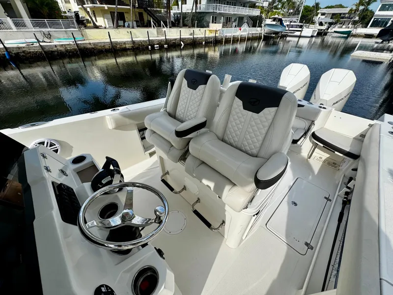 Slide: The Image of 2022 Sailfish 290 CC boat interior with dual captain's chairs and steering wheel. - 15
