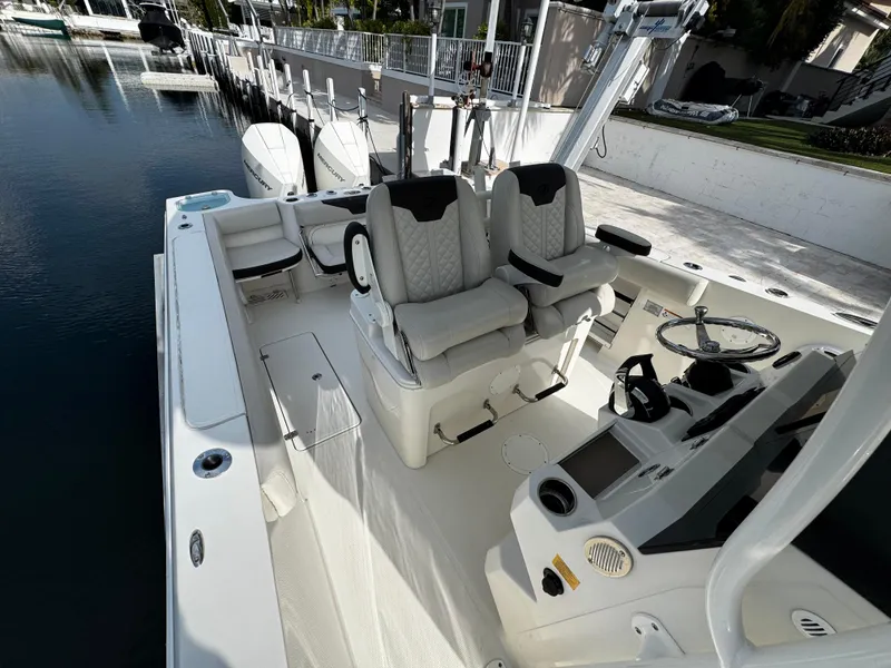 Slide: The Image of 2022 Sailfish 290 CC boat interior with dual seats and steering console. - 16