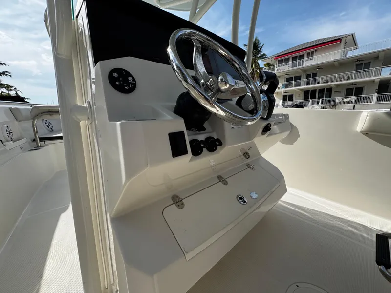 Slide: The Image of 2022 Sailfish 290 CC boat helm with steering wheel and controls. - 24