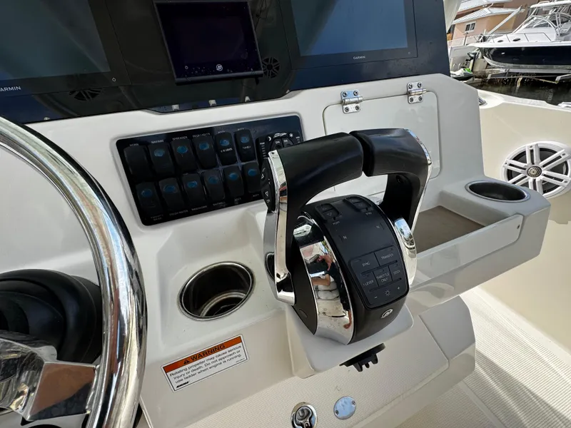 Slide: The Image of Control panel of 2022 Sailfish 290 CC boat with steering wheel and throttle. - 26
