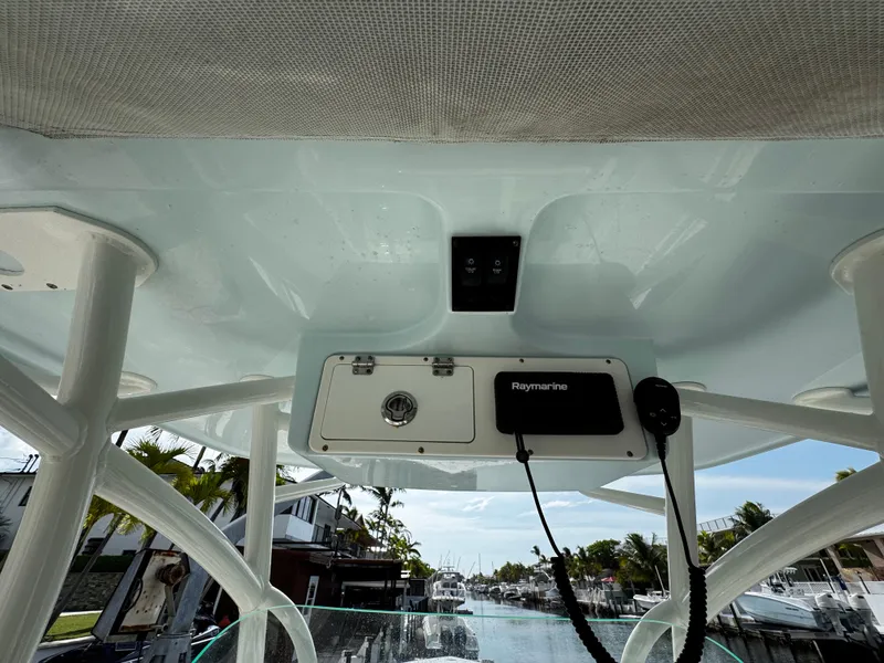 Slide: The Image of 2022 Sailfish 290 CC boat console with Raymarine equipment, docked near waterfront homes. - 28