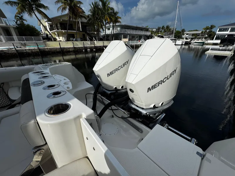 Slide: The Image of 2022 Sailfish 290 CC boat with dual Mercury outboard engines docked in a marina. - 31