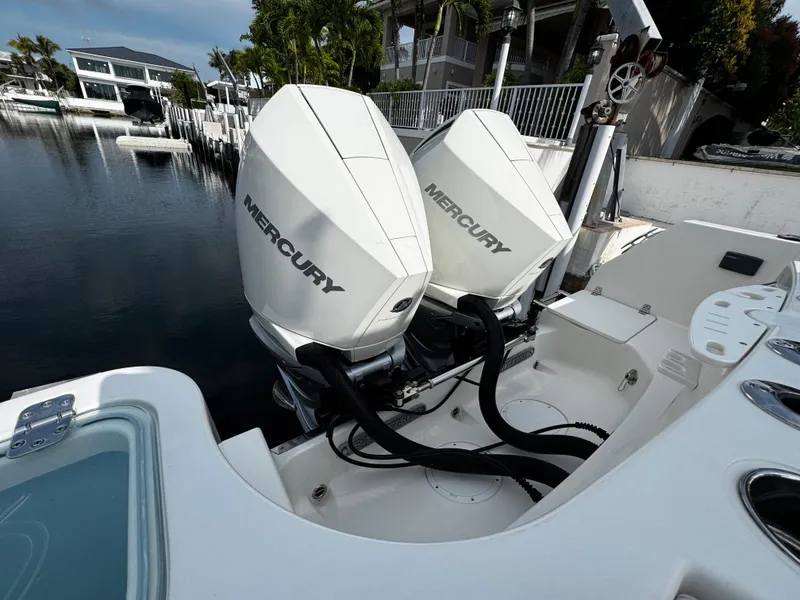 Slide: The Image of Twin Mercury outboard engines on a 2022 Sailfish 290 CC boat docked by the water. - 32