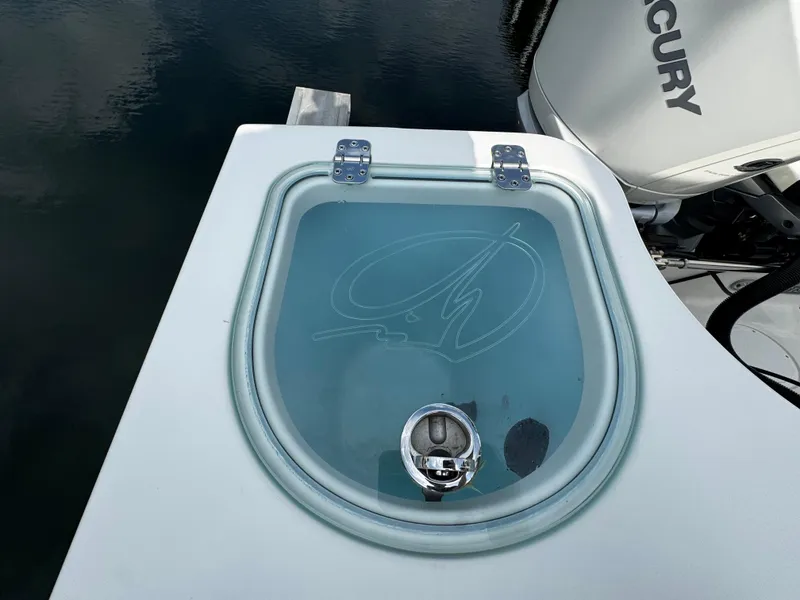 Slide: The Image of 2022 Sailfish 290 CC livewell with transparent lid and Mercury engine in background. - 33
