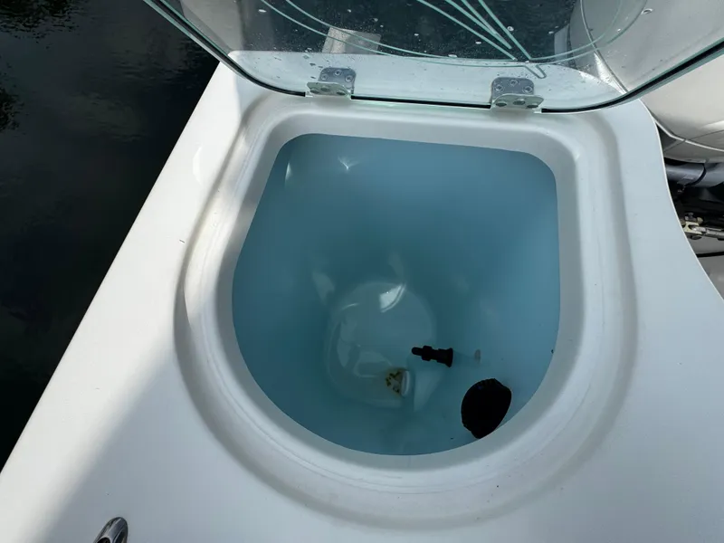 Slide: The Image of Open livewell on 2022 Sailfish 290 CC boat, showing interior with water and objects. - 34