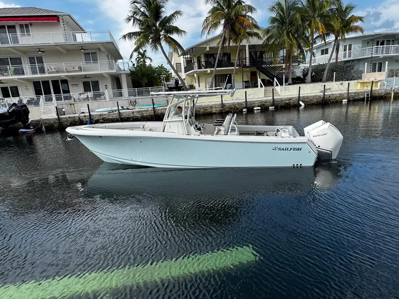 Slide: The Image of 2022 Sailfish 290 CC boat docked near waterfront homes with palm trees. - 4
