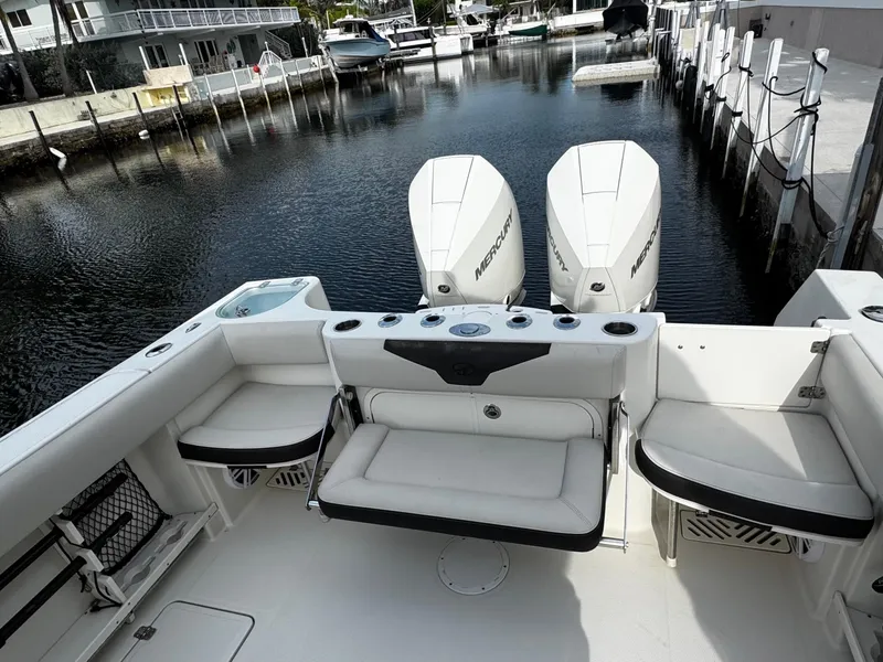 Slide: The Image of 2022 Sailfish 290 CC boat with triple outboard engines docked in a marina. - 9